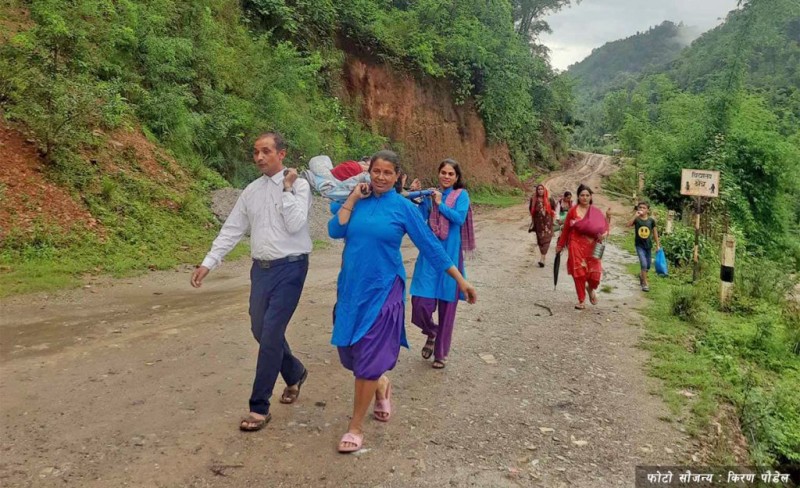 स्वास्थ्यकर्मीले सुत्केरीलाई बोक्दा स्थानीय रमिते